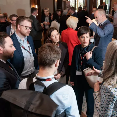 A group of people in smart causal clothing talk in a group.