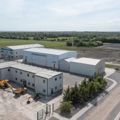 Modern white buildings with construction equipment outside that make up the National Training Campus.