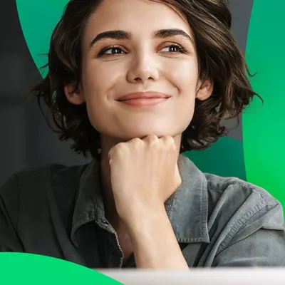 A female with short brown hair rests her chin in her hand, smiling.