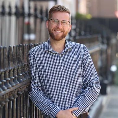 Headshot of a person standing outside a building.