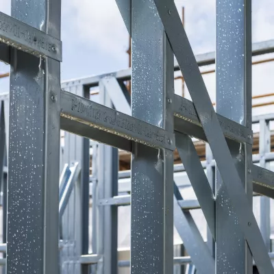 Close-up of light steel frame structure at a construction site.