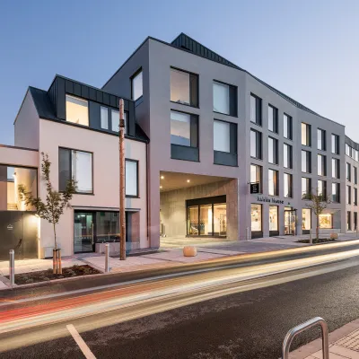 A modern multi-storey building with large windows and a sign reading "Ashlin House" on the facade
