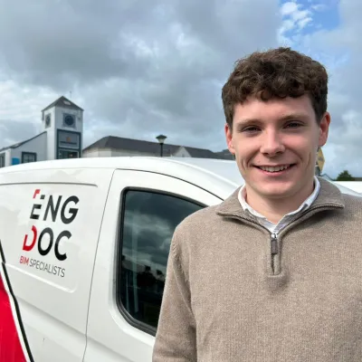 A person is standing in front of a minivan with the Engdoc logo.