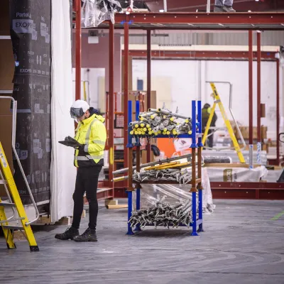Workers in protective gear performing installation tasks inside an industrial facility