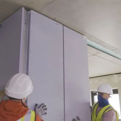 People in high-vis vests working with walls.