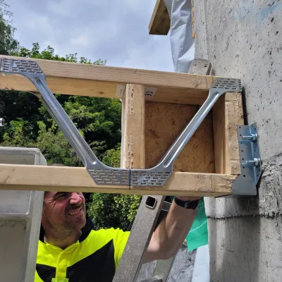 Close-up of a construction worker securing a timber beam