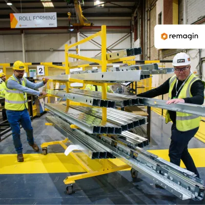 Workers in safety gear operating a material lifting system in a manufacturing facility with Pennoin logo.
