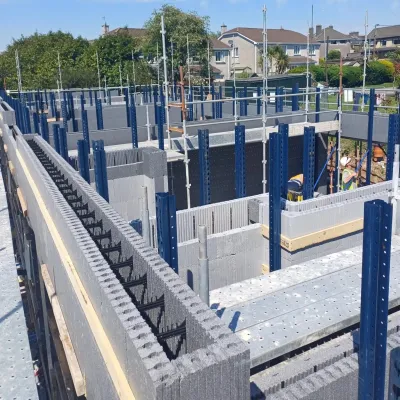 Construction site with insulated concrete form blocks and scaffolding in place.
