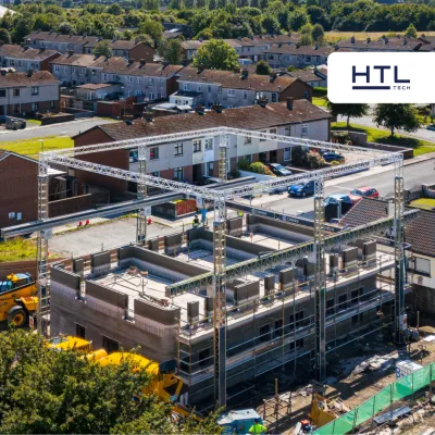 Aerial view of a multi-story building under construction with scaffolding in a residential area.