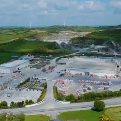 Aerial view of an industrial site with excavation areas surrounded by green countryside.