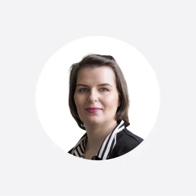 Professional headshot of a woman with short dark hair in a circular frame.