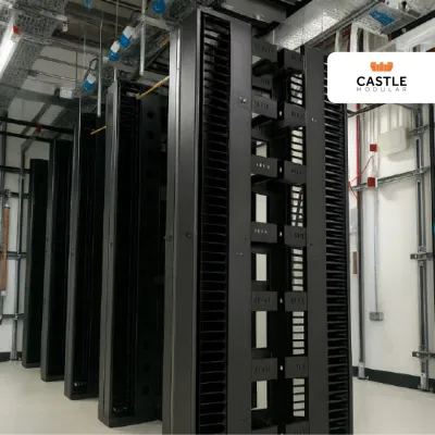 Rows of black server racks in a data center with Castle logo in the corner.