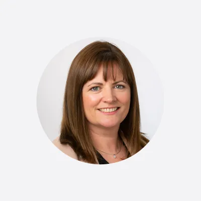 Smiling woman with brown hair in a professional circular portrait photo.