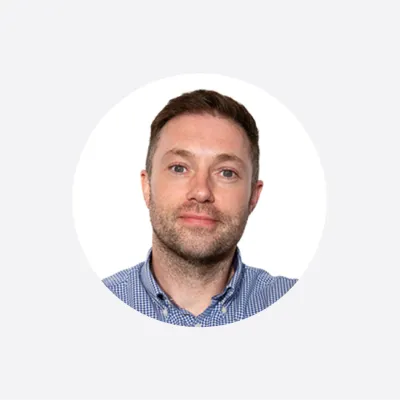 Headshot of a man in a blue striped shirt, circular cropped portrait photo.
