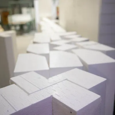 Rows of white foam or polystyrene blocks stacked in an industrial warehouse.