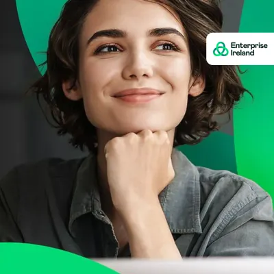 Smiling young woman resting chin on hand, with Enterprise Ireland logo in the corner.