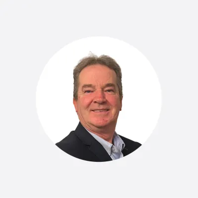 Smiling middle-aged man in a dark blazer, professional headshot photo.