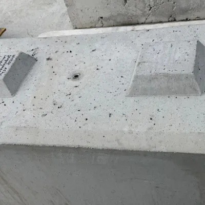 Large gray concrete block with two rectangular protrusions on top, outdoors.
