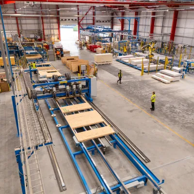Aerial view of a large industrial warehouse with automated conveyor systems and workers in high-visibility vests.